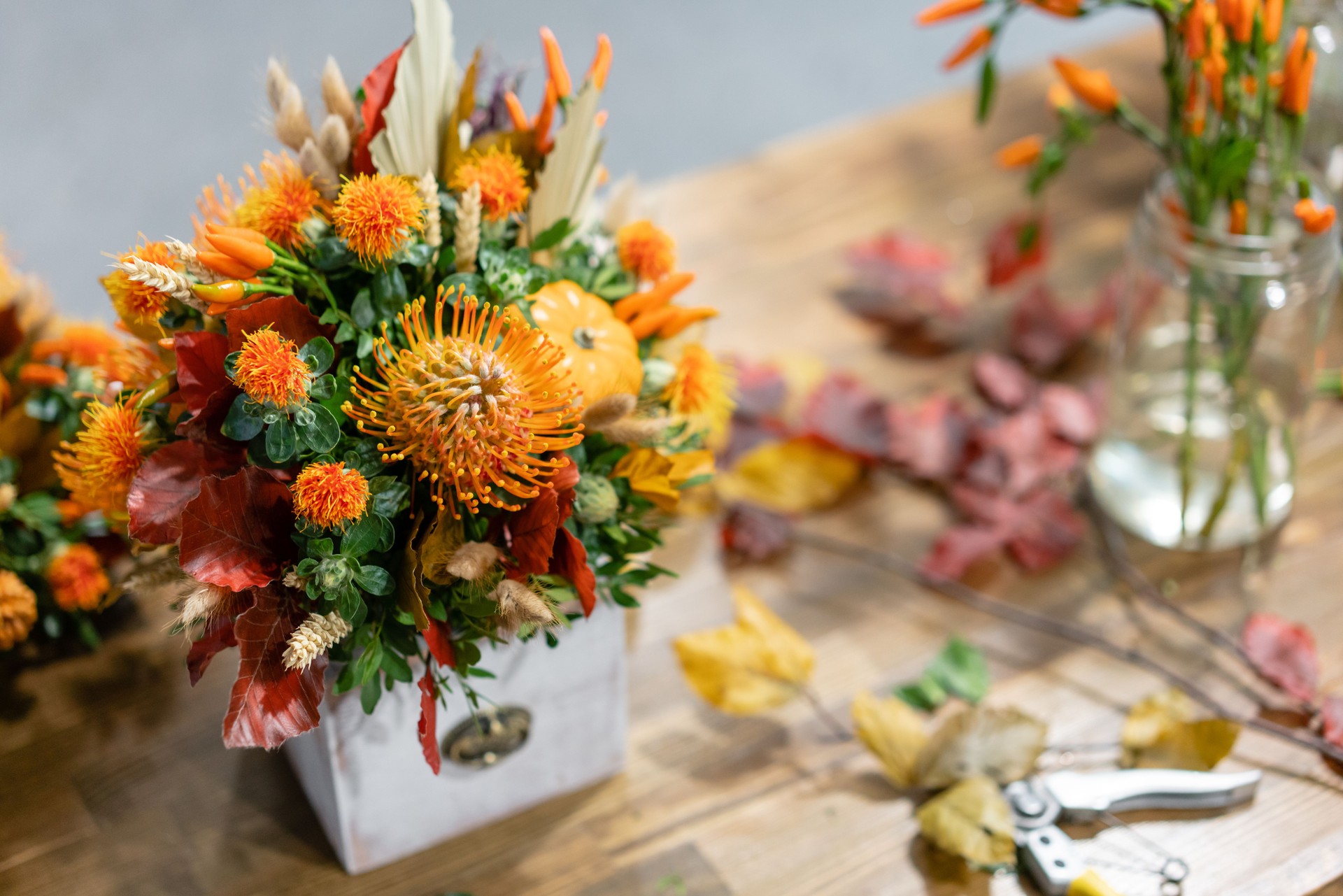 Process of creating Autumn bouquet of mixed flowers on wooden table. The work of the florist at a flower shop. Fresh cut flower.